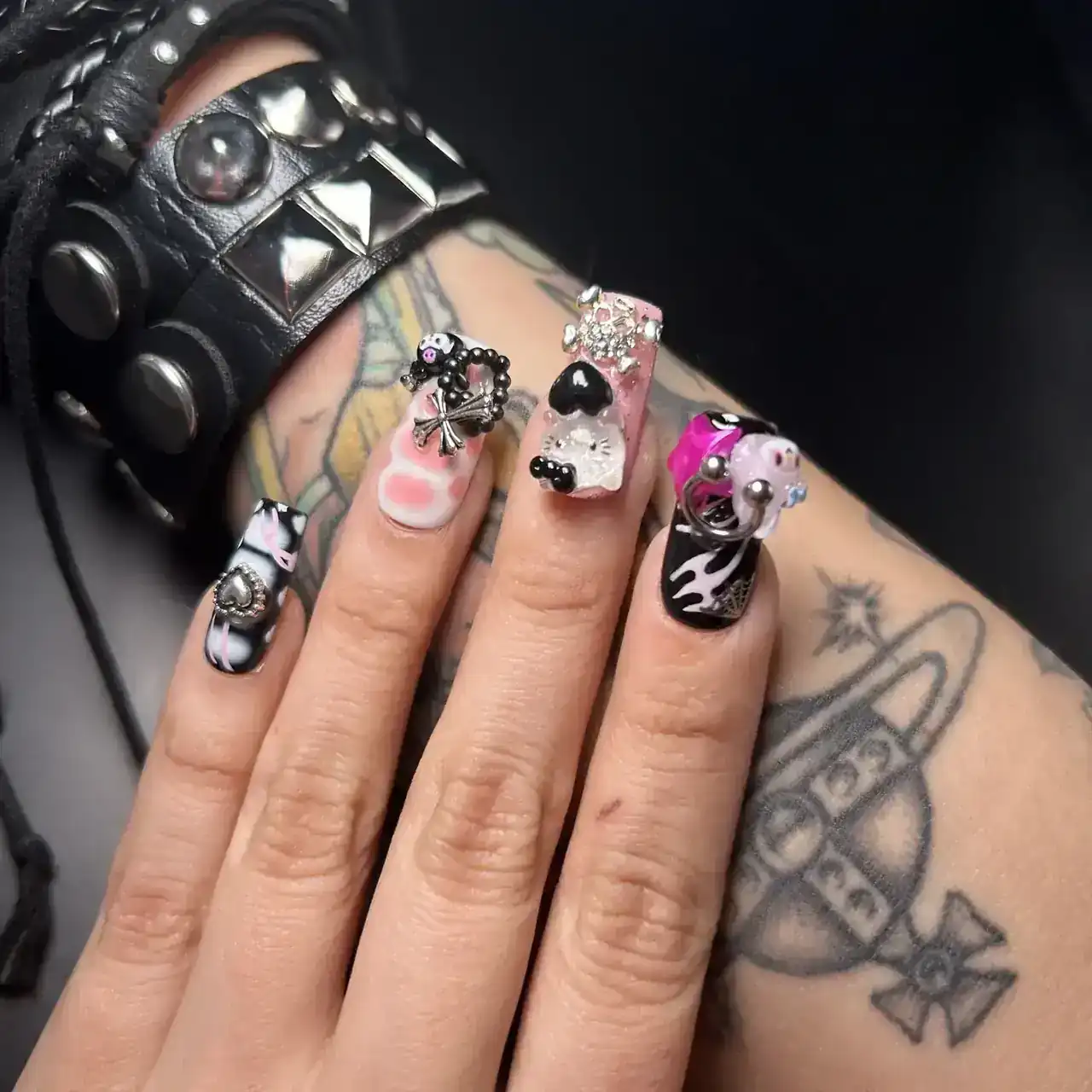 Black and pink nail details paired with silver jewelry and leather.